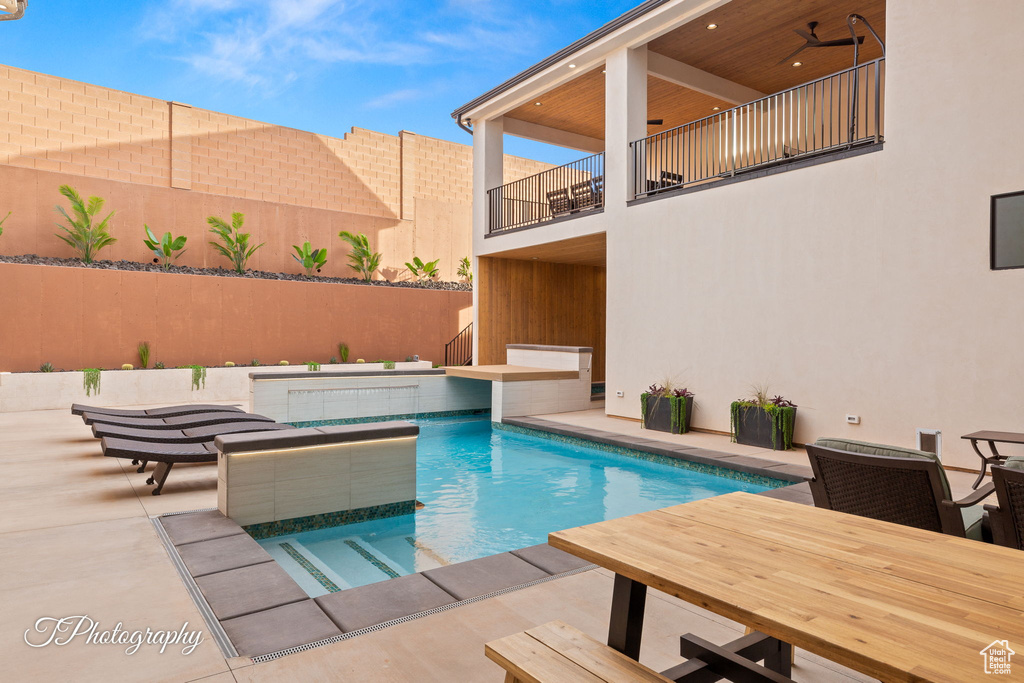View of pool with a patio area and fence