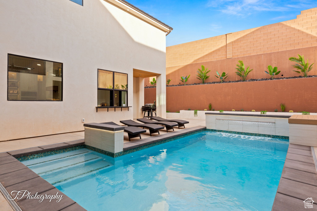 Outdoor pool with a fenced backyard and a patio