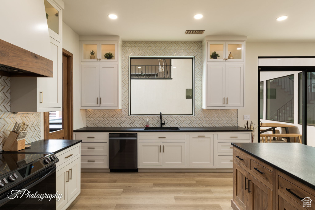 Kitchen featuring black appliances, dark countertops, a sink, backsplash, and recessed lighting
