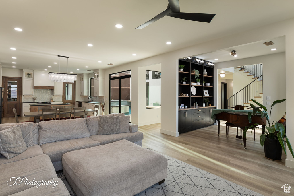 Living area featuring light wood-style flooring, recessed lighting, stairs, and ceiling fan