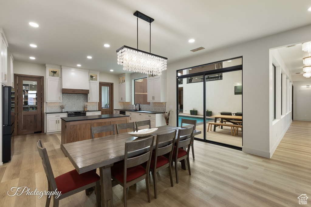 Dining area featuring a chandelier, light wood-style flooring, and recessed lighting
