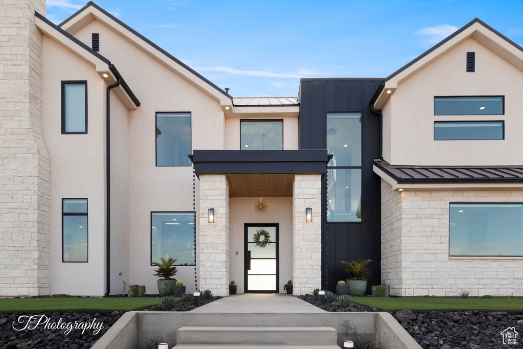 View of front of property featuring a standing seam roof, metal roof, and stucco siding