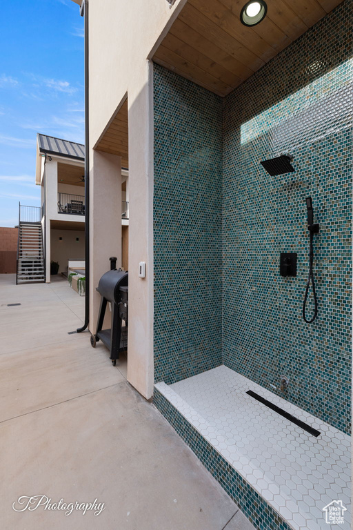 Full bath with a tile shower and concrete flooring