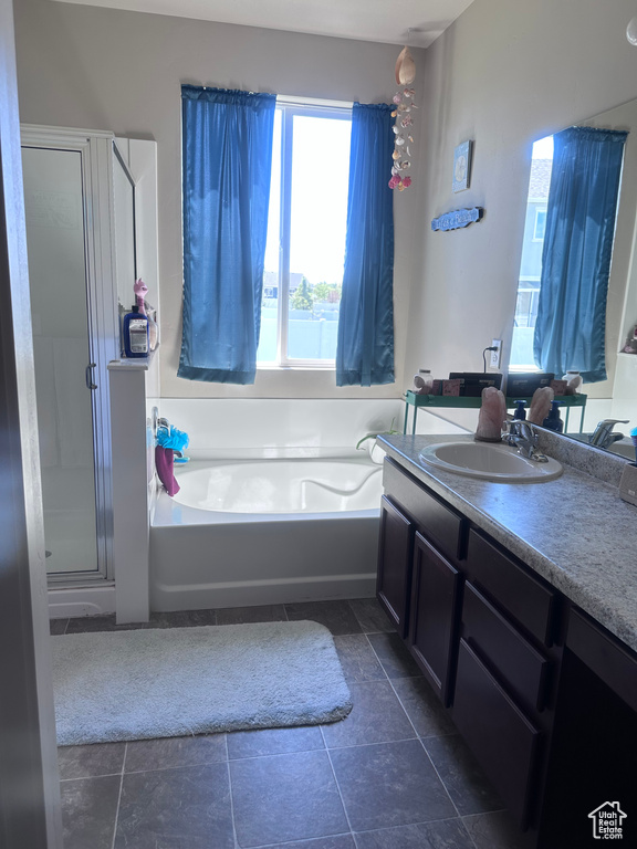 Bathroom featuring vanity, a bath, and a shower stall