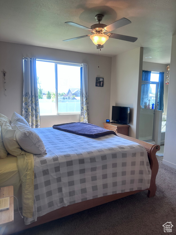Carpeted bedroom featuring ceiling fan
