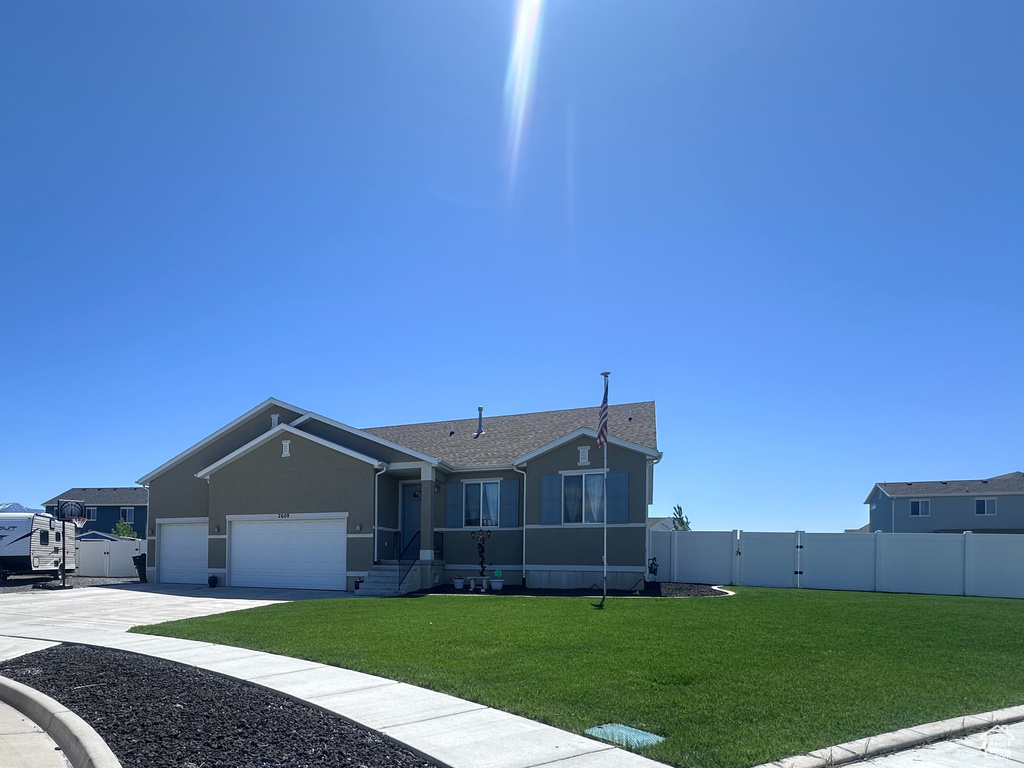 View of front of home with concrete driveway, an attached garage, and stucco siding