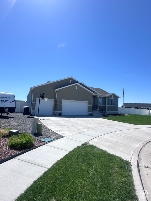 View of front of property featuring stucco siding, an attached garage, and concrete driveway
