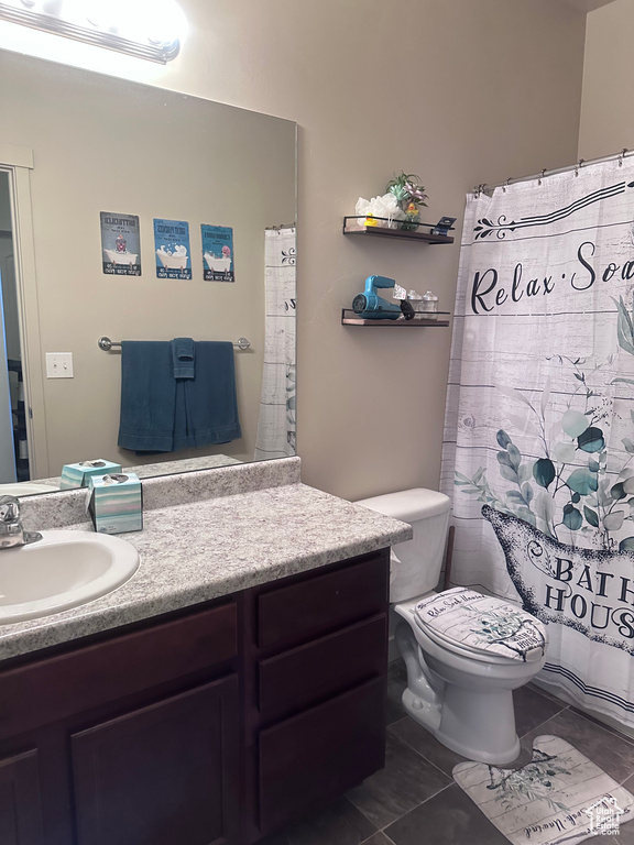 Full bathroom featuring vanity, tile patterned flooring, and toilet