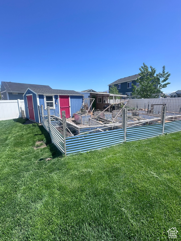 View of yard with a shed, a vegetable garden, and an outdoor structure