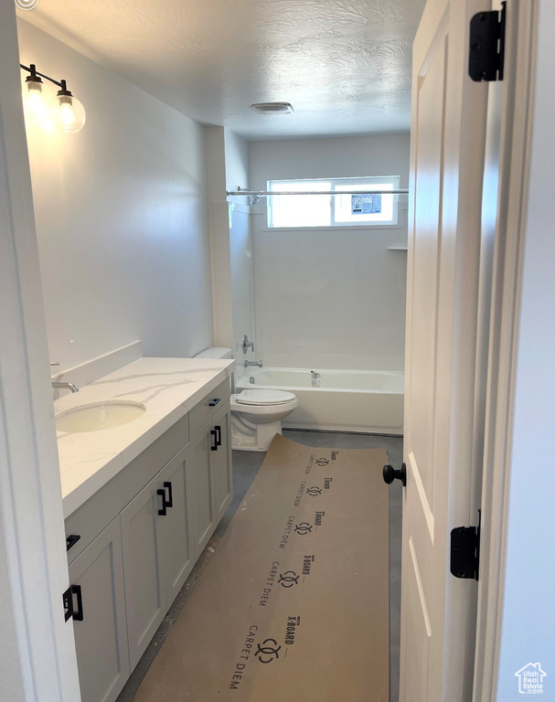 Full bathroom featuring toilet, vanity, a textured ceiling, and shower / bathtub combination