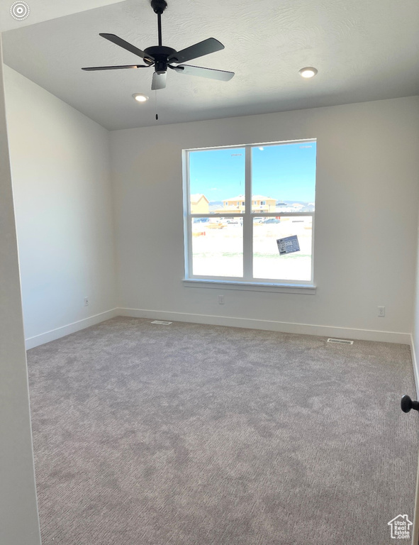 Carpeted spare room featuring ceiling fan, baseboards, and recessed lighting
