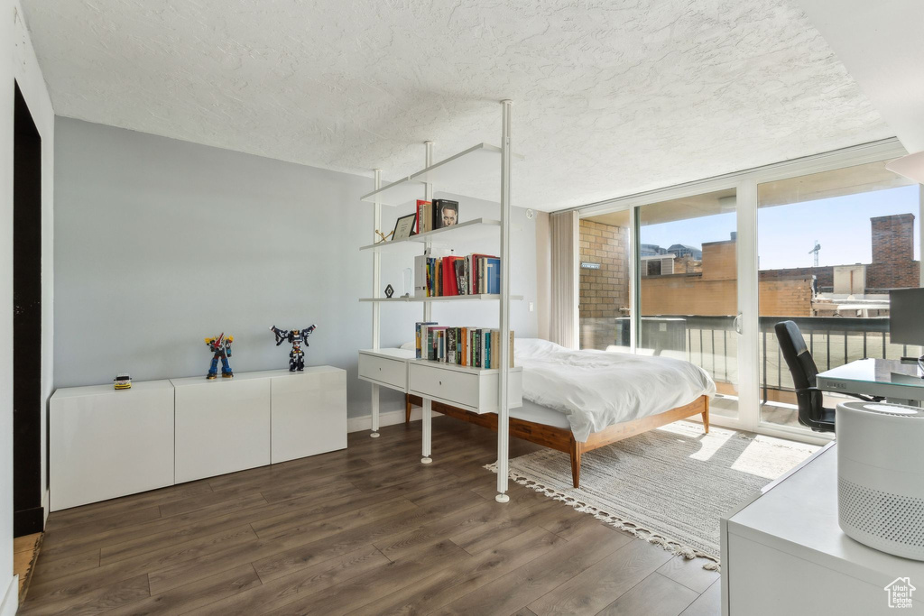 Bedroom featuring wood finished floors, access to exterior, and a textured ceiling