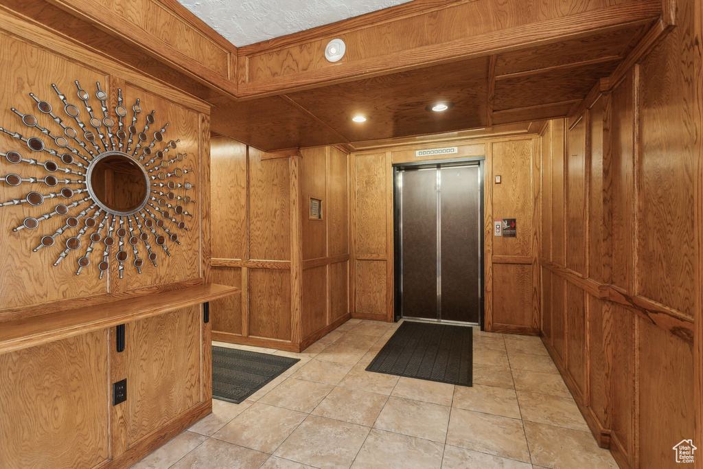 Foyer featuring elevator and wooden walls