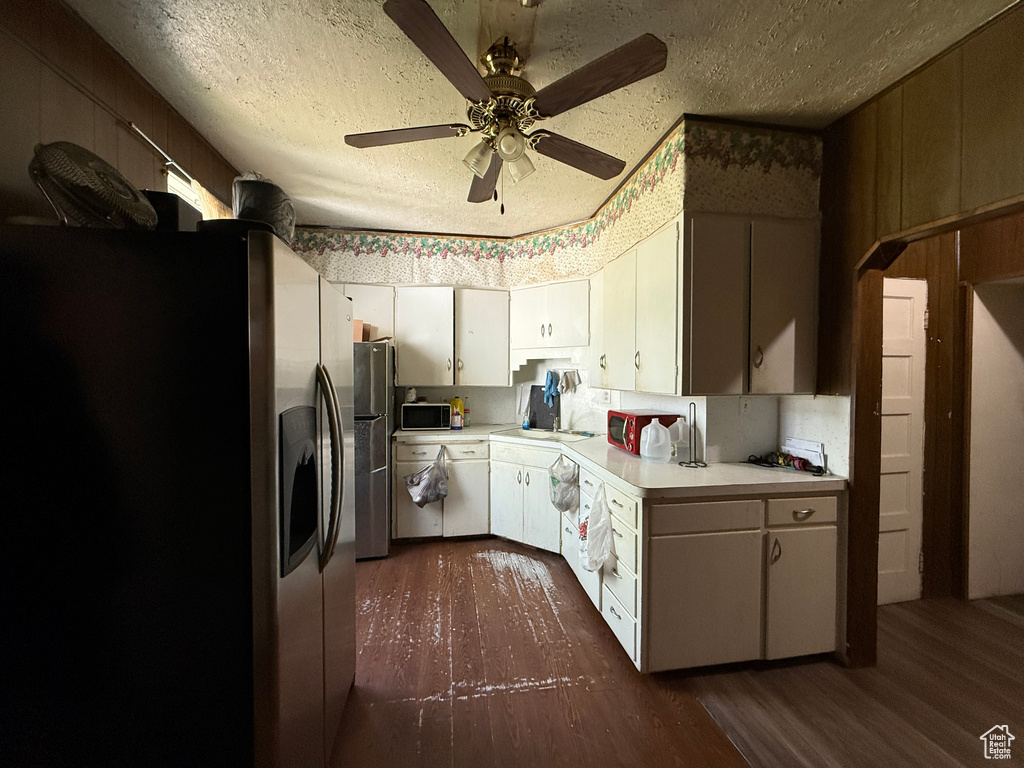 Kitchen featuring stainless steel fridge with ice dispenser, dark wood-style floors, light countertops, a textured ceiling, and a ceiling fan