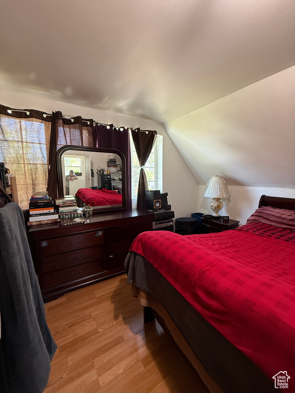 Bedroom featuring light wood-type flooring and lofted ceiling
