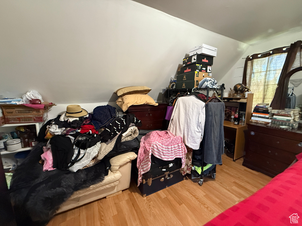 Bedroom featuring wood finished floors and vaulted ceiling