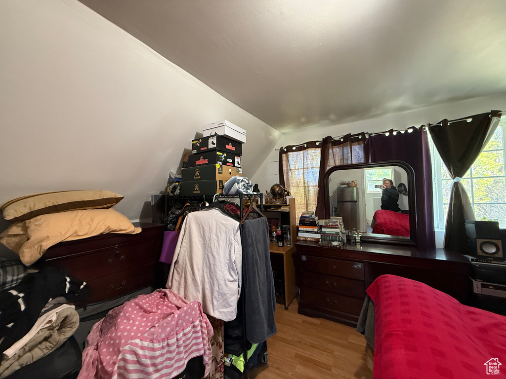 Bedroom with wood finished floors and lofted ceiling