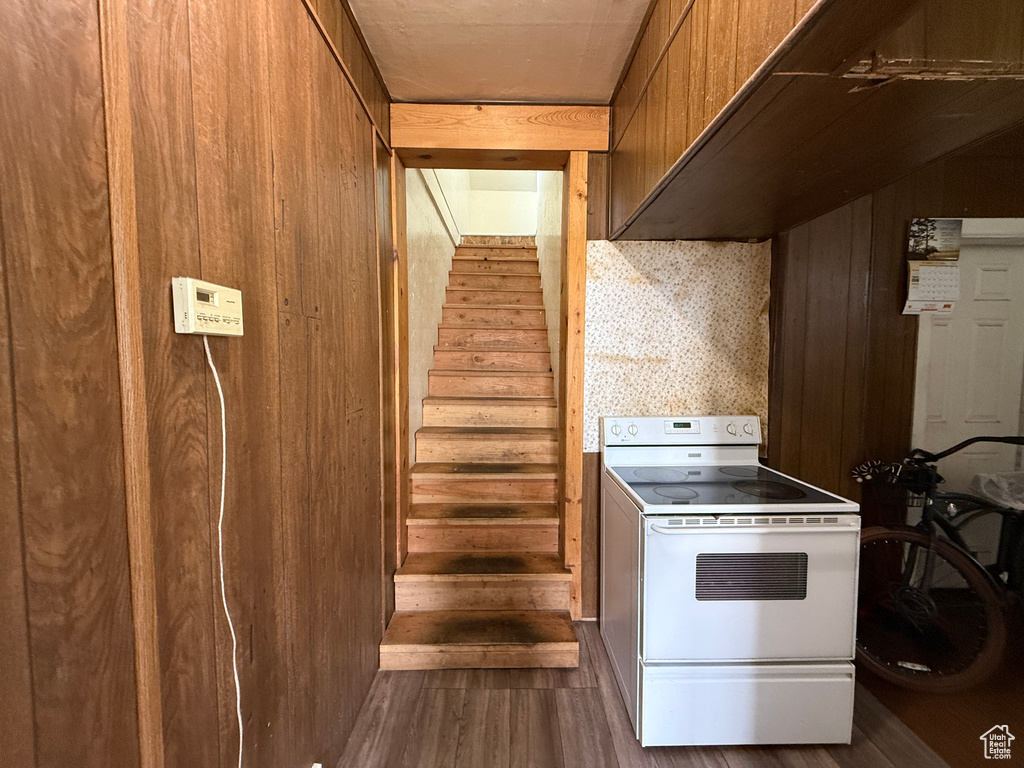 Stairs featuring wood finished floors and wooden walls