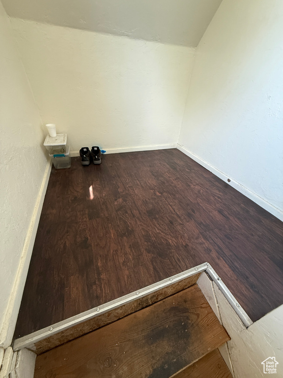 Spare room with lofted ceiling, wood finished floors, and baseboards