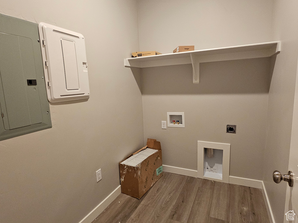 Washroom with wood finished floors, hookup for a washing machine, hookup for an electric dryer, baseboards, and electric panel