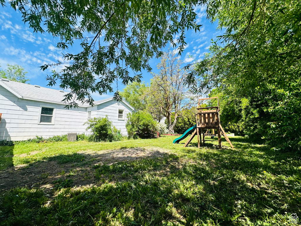 View of grassy yard featuring a playground