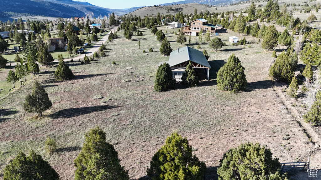 Aerial view of property and surrounding area with a mountain backdrop