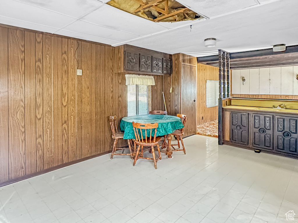 Dining area with wood walls and tile patterned floors