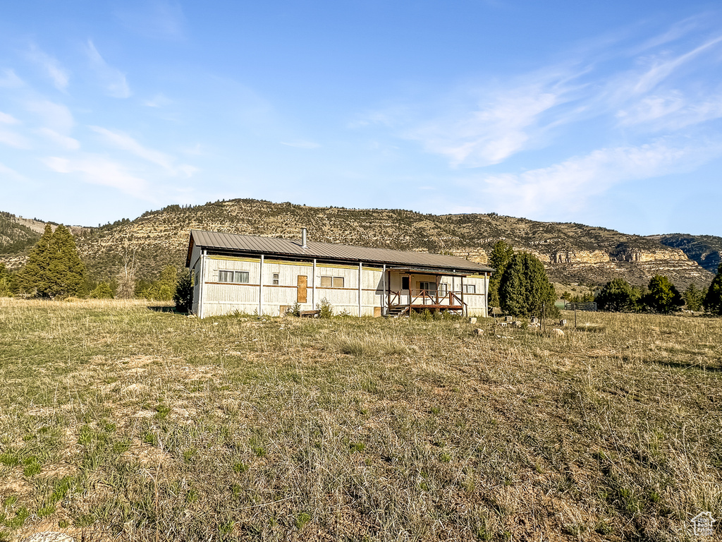 Back of property with a mountain view and metal roof