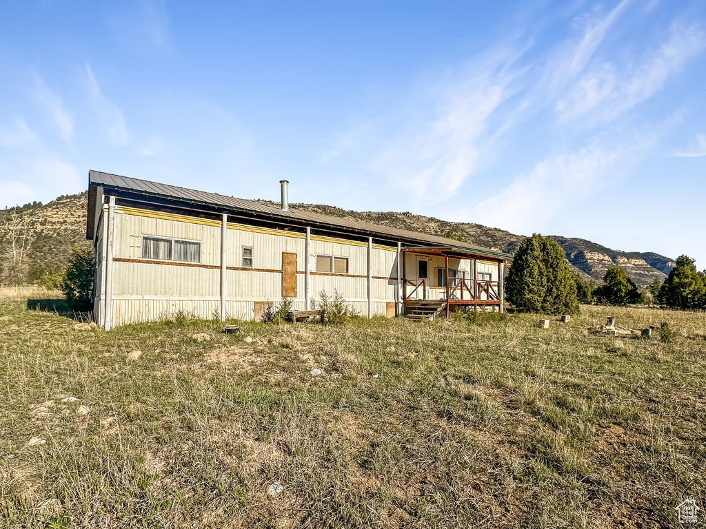 Back of property featuring metal roof, a pole building, and a deck with mountain view