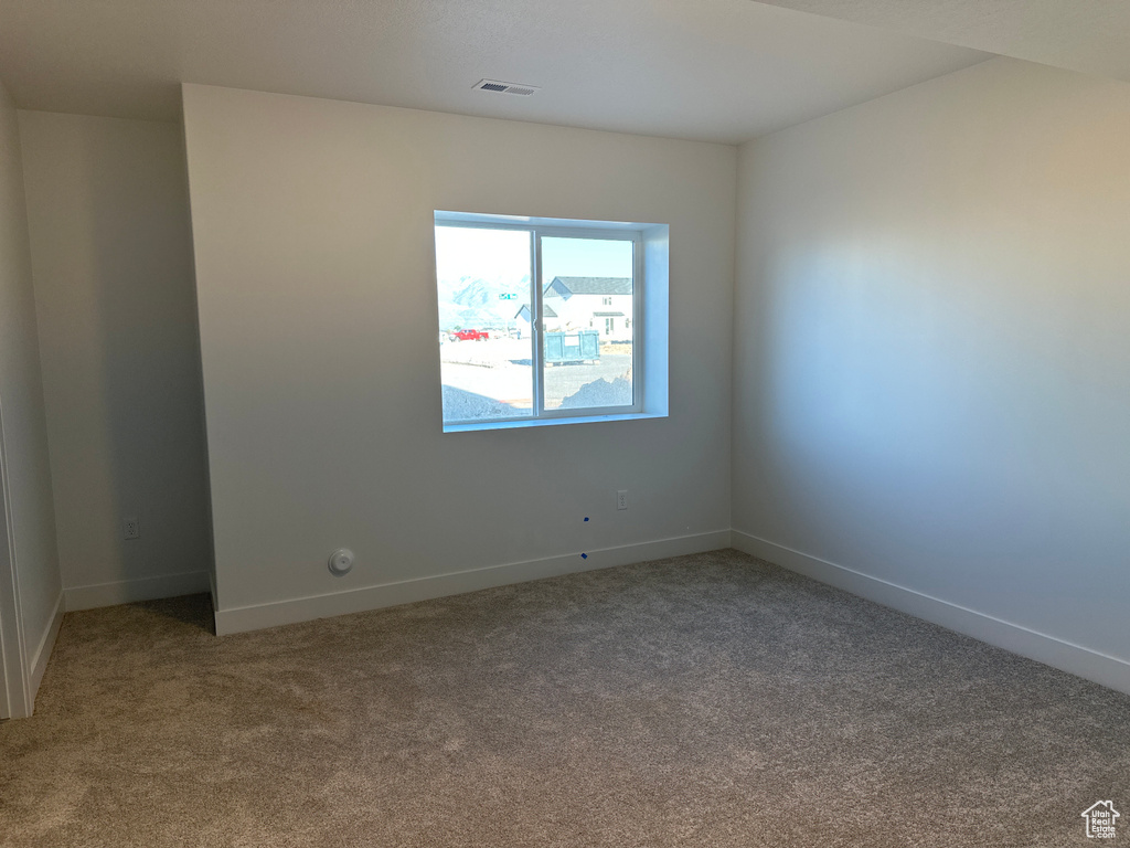 Carpeted empty room with baseboards