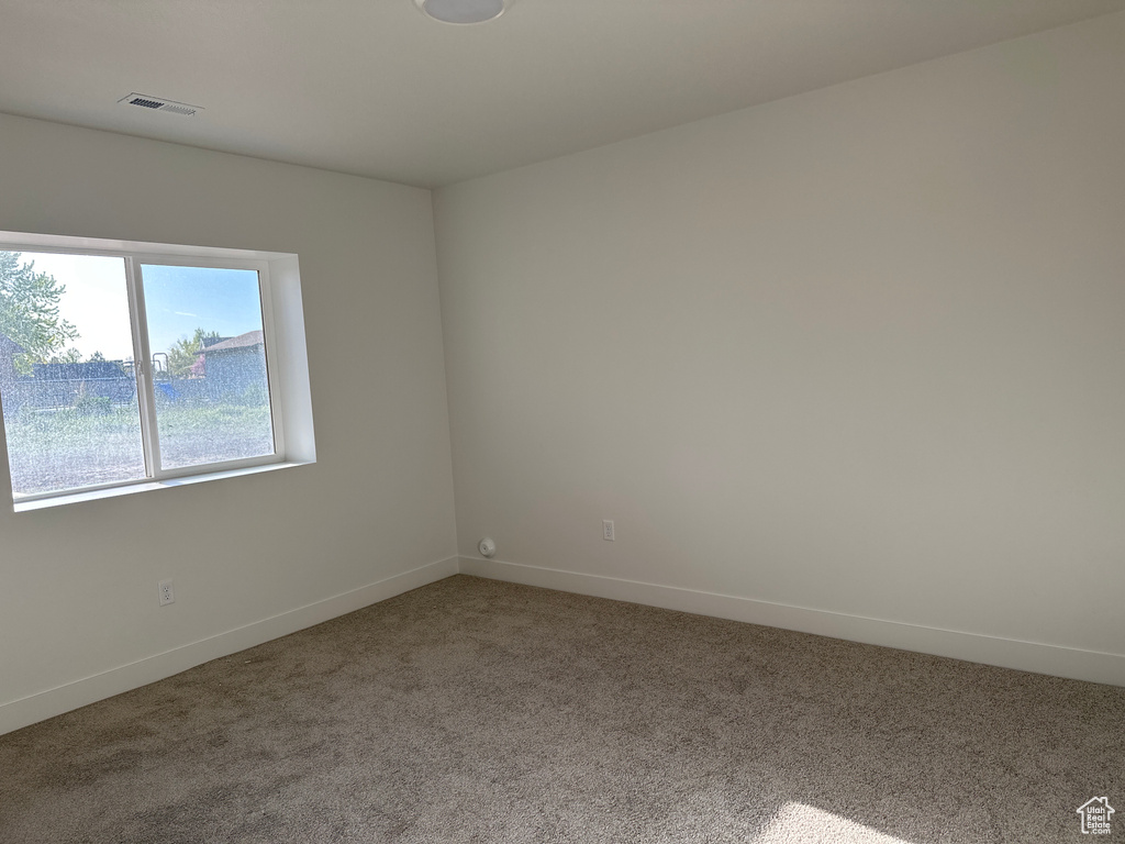 Spare room featuring carpet floors and baseboards