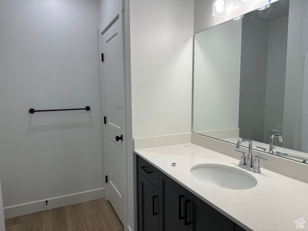Bathroom featuring toilet, wood finished floors, and vanity