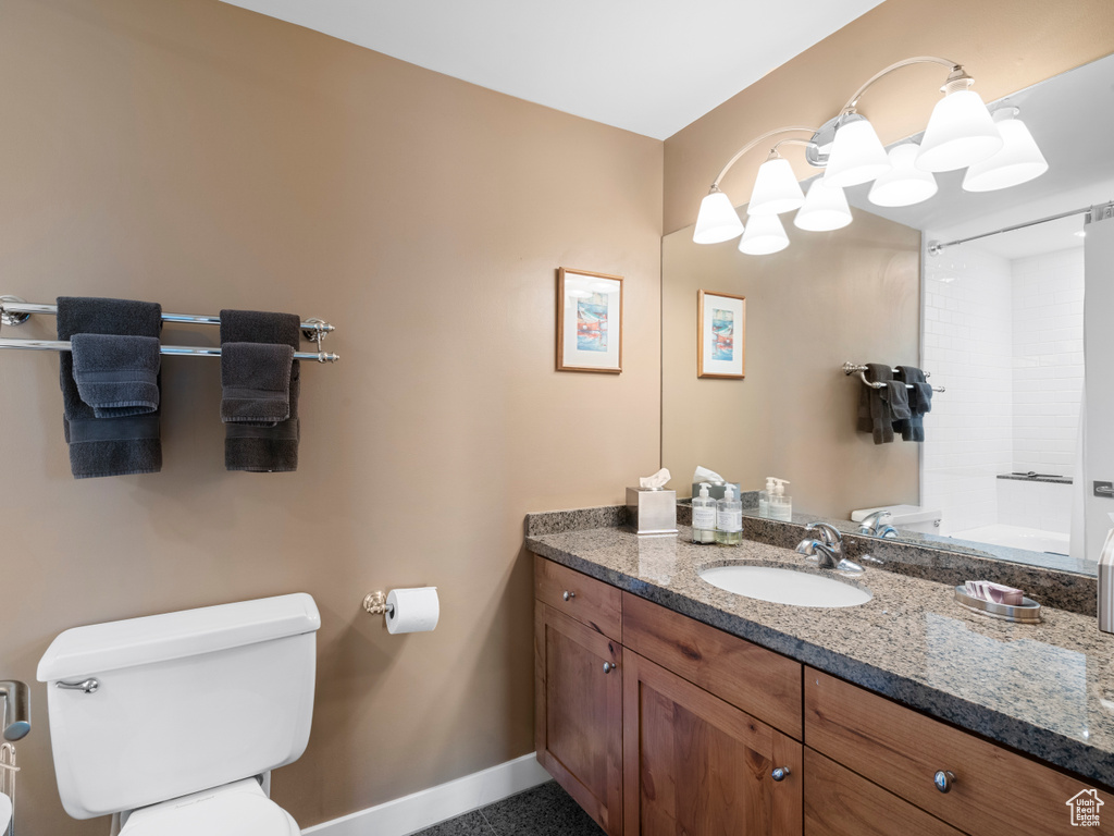 Bathroom featuring toilet, vanity, and baseboards