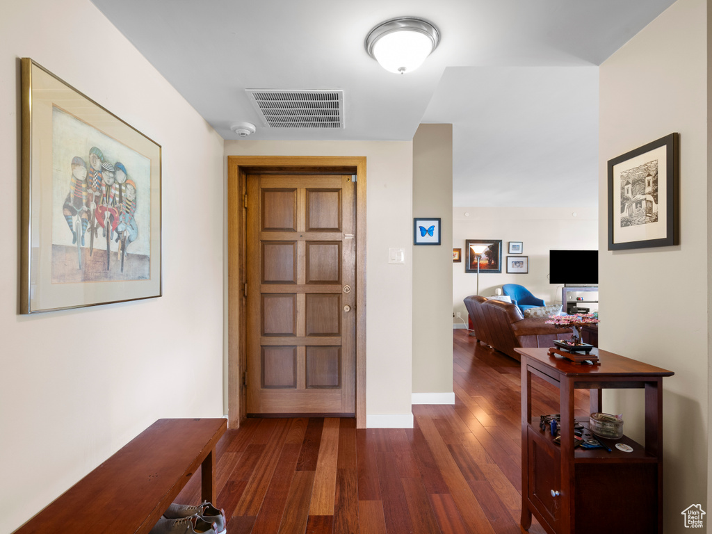 Hall with dark wood-type flooring and baseboards