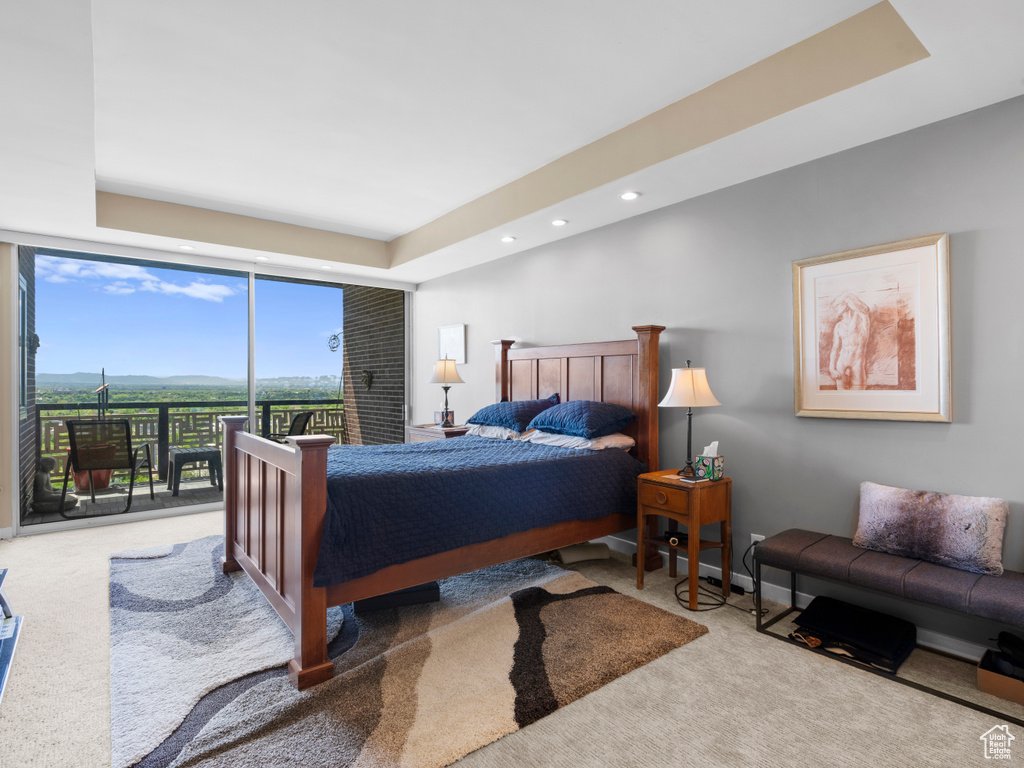 Carpeted bedroom featuring access to outside, recessed lighting, a wall of windows, and a raised ceiling