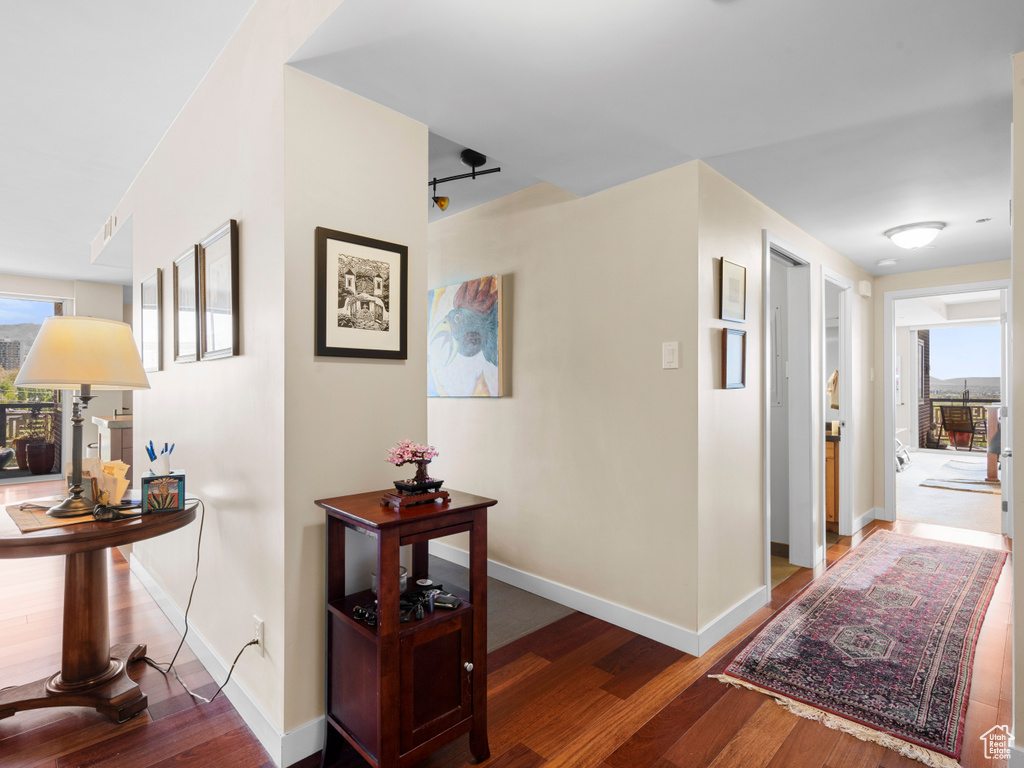 Corridor featuring healthy amount of natural light, wood finished floors, and baseboards