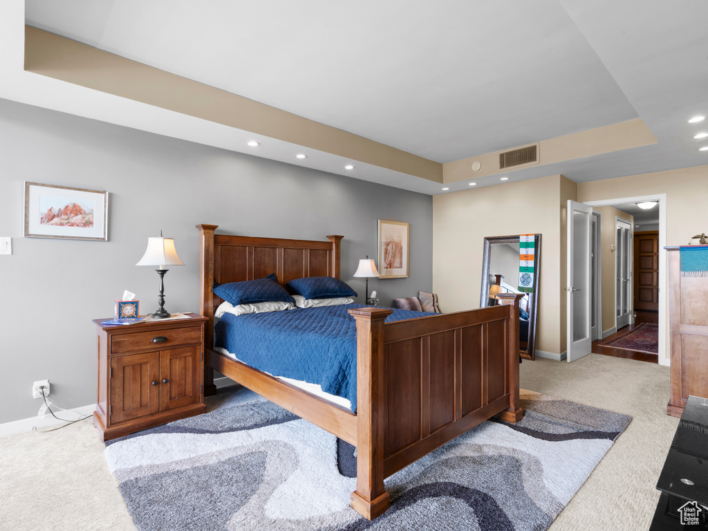 Bedroom featuring carpet flooring, baseboards, recessed lighting, and a tray ceiling