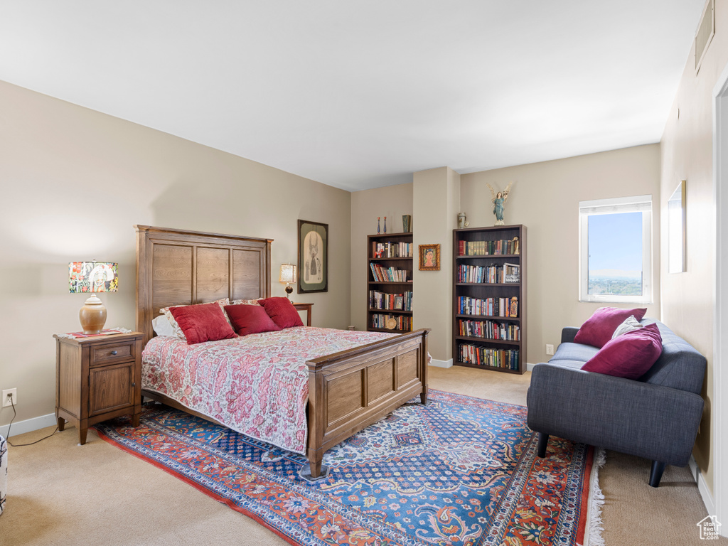 Bedroom featuring light carpet and baseboards