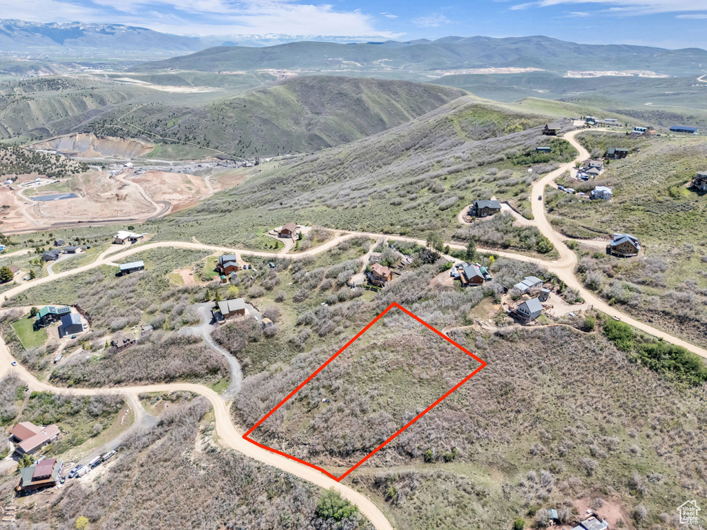 Aerial view of property and surrounding area with property boundaries highlighted, mountains, and rural landscape