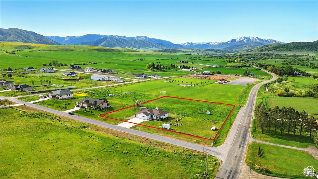 View of rural area featuring property parcel outlined, a mountain backdrop, and agricultural land