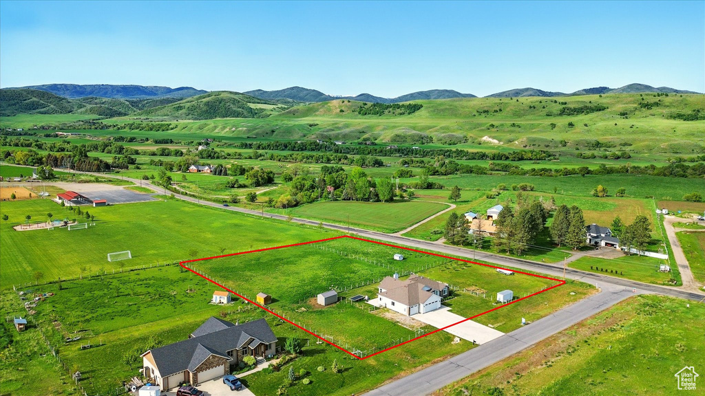 Overview of rural landscape featuring property boundaries highlighted and a mountain backdrop