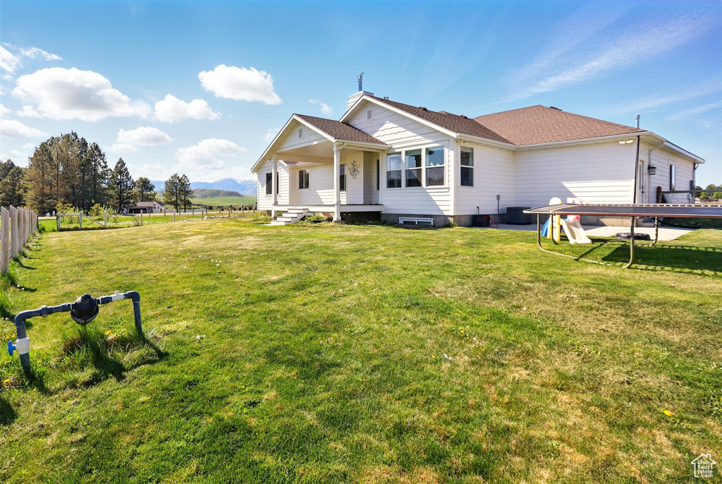 Rear view of house with central AC and a mountain view