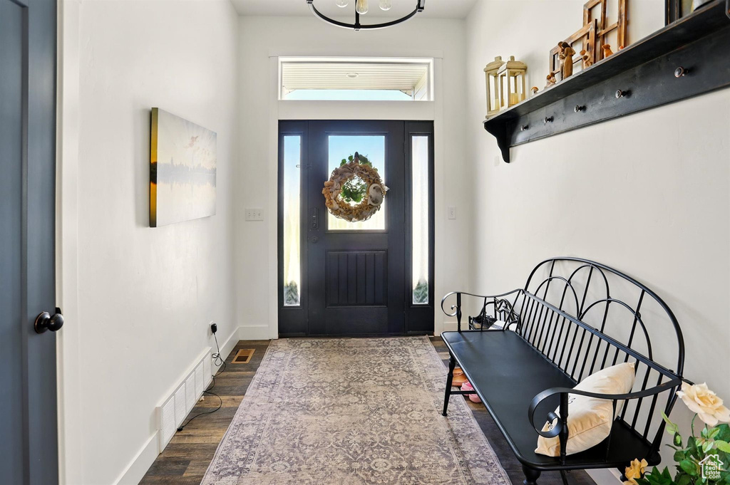Foyer entrance with dark wood-style floors and baseboards