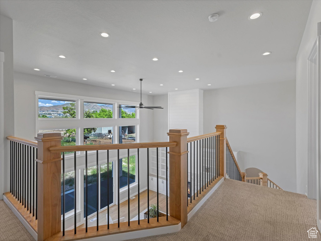 Hall with an upstairs landing, recessed lighting, and carpet floors
