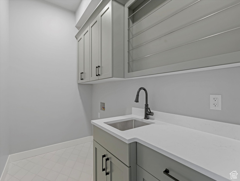 Washroom with washer hookup, cabinet space, and baseboards