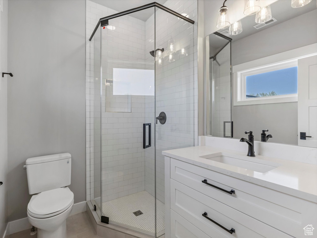 Full bathroom featuring a shower stall, vanity, toilet, and baseboards