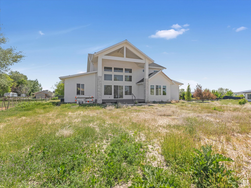 Rear view of property with stucco siding and fence