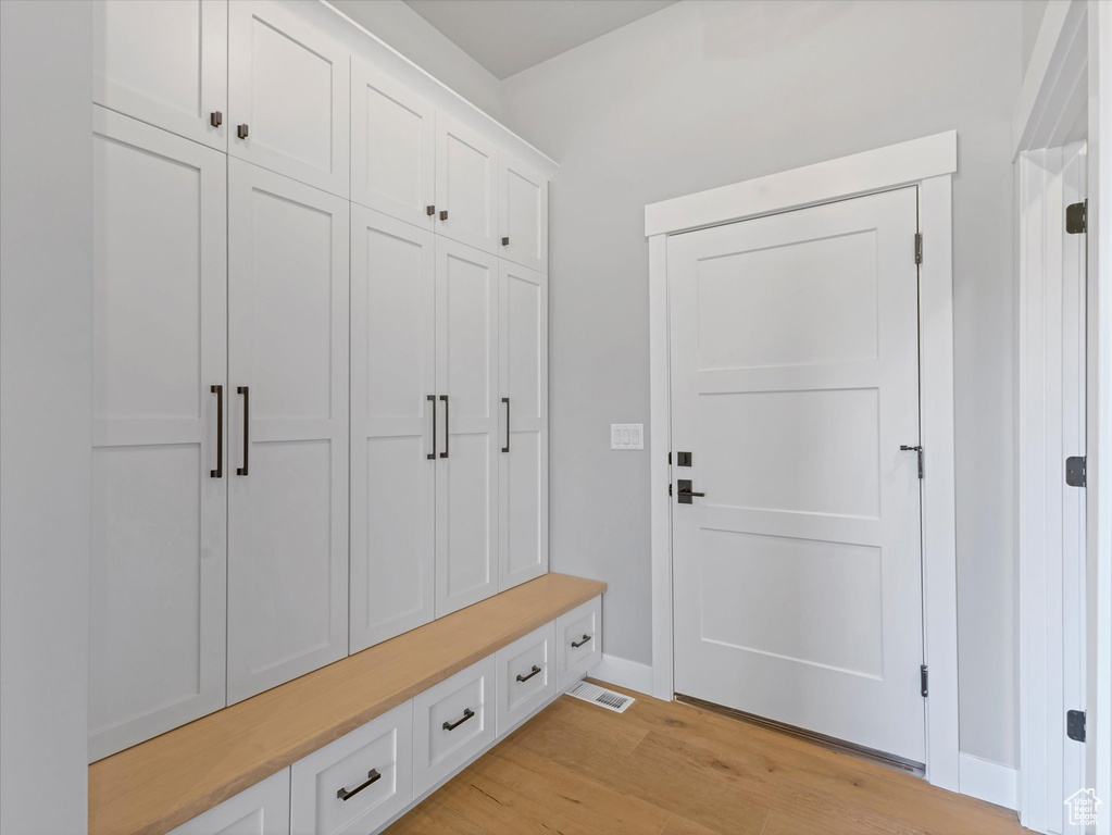 Mudroom with light wood-type flooring and baseboards
