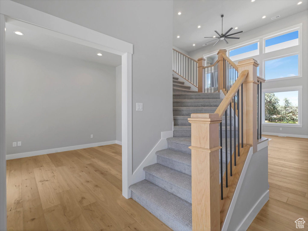 Staircase featuring wood finished floors, recessed lighting, and baseboards