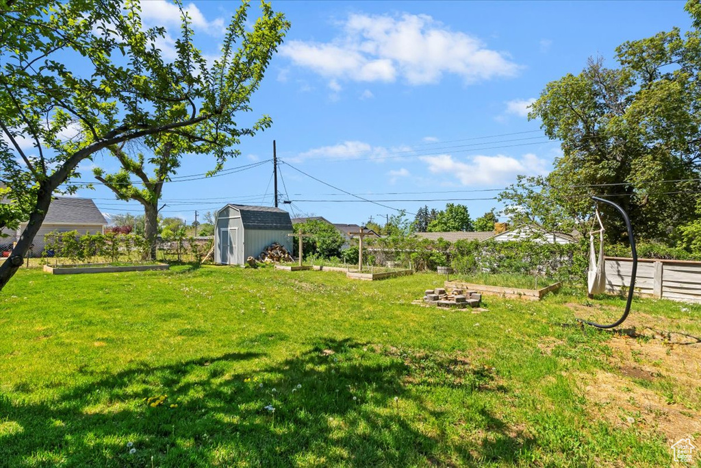View of yard with a vegetable garden, a shed, and an outdoor structure